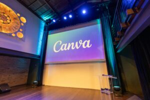 Stage setup with a large screen displaying Canva logo, ready for a presentation.